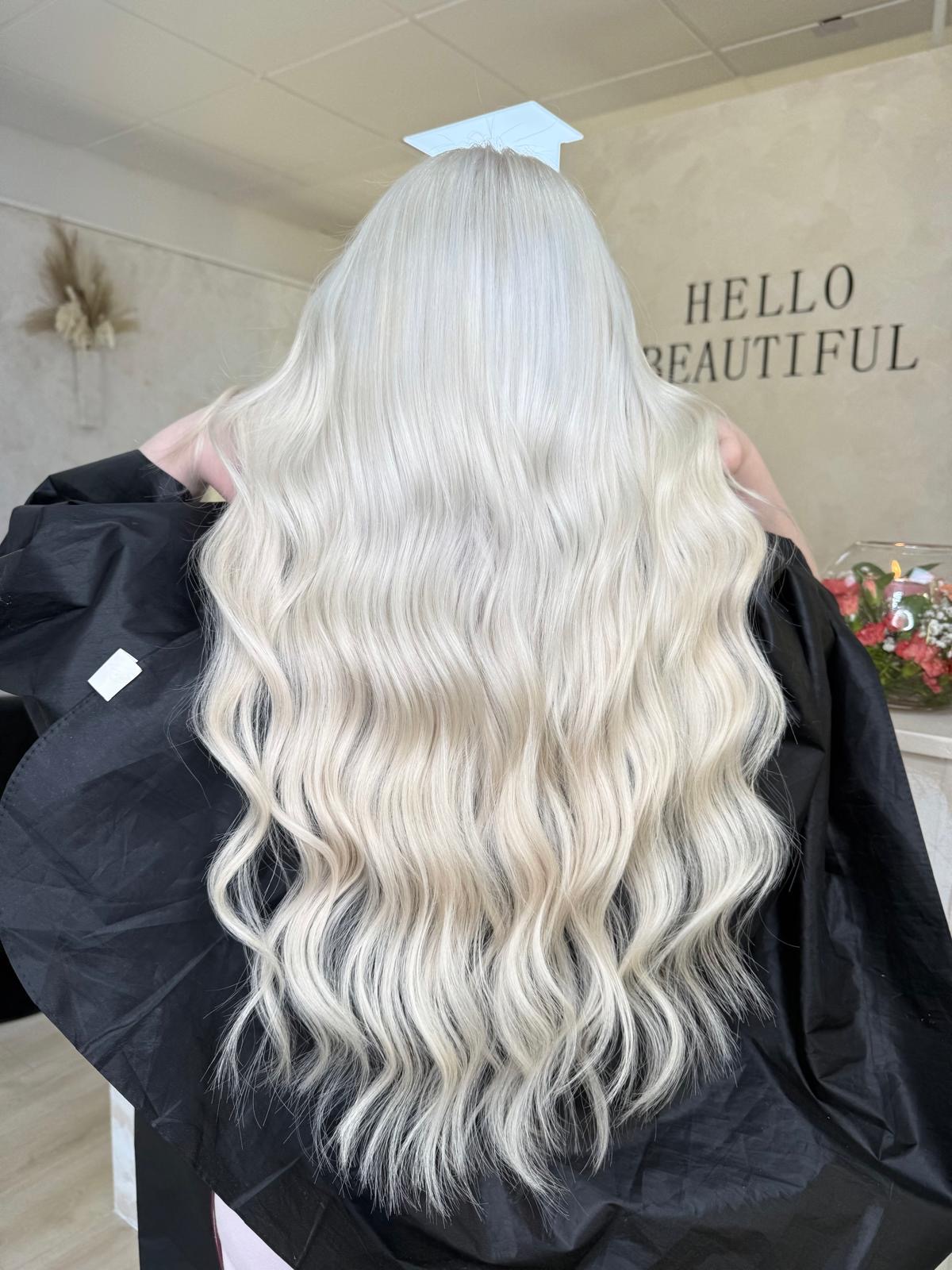 Long icy blonde hair with soft waves after extensions