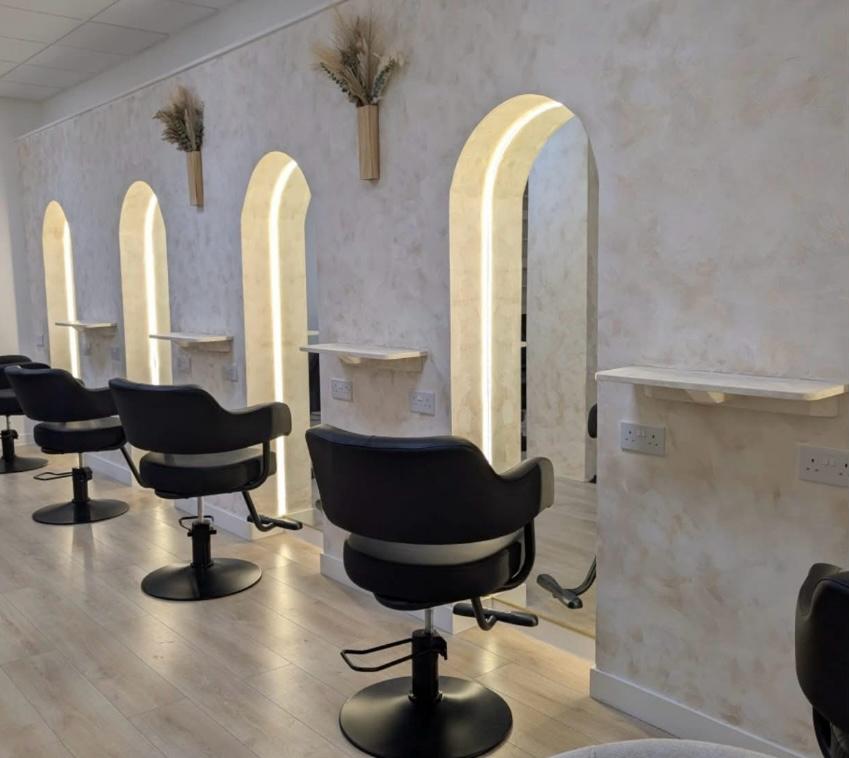 EnvyLocks by Shannon salon interior with backlit arched mirrors and black styling chairs